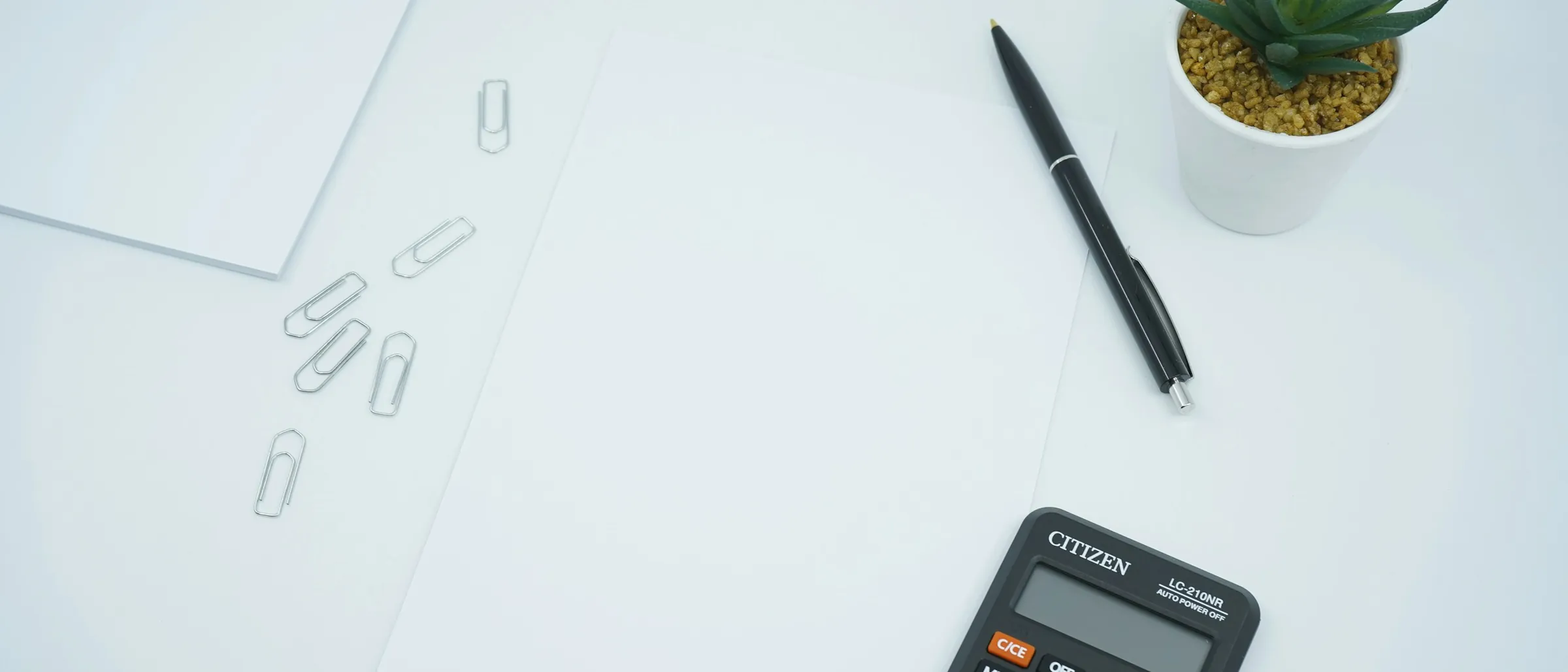 A clean desk with a notebook and pen set square to the edge