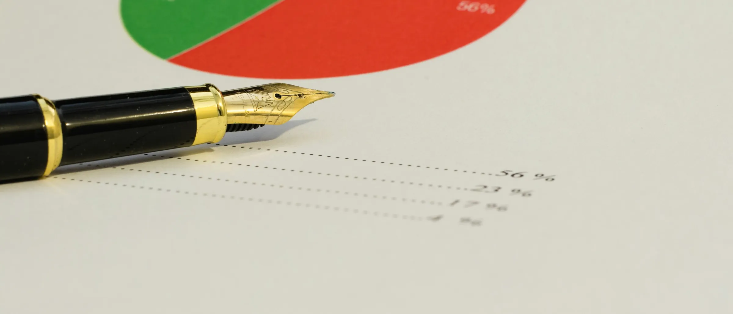 A fountain pen resting on a printed pie chart