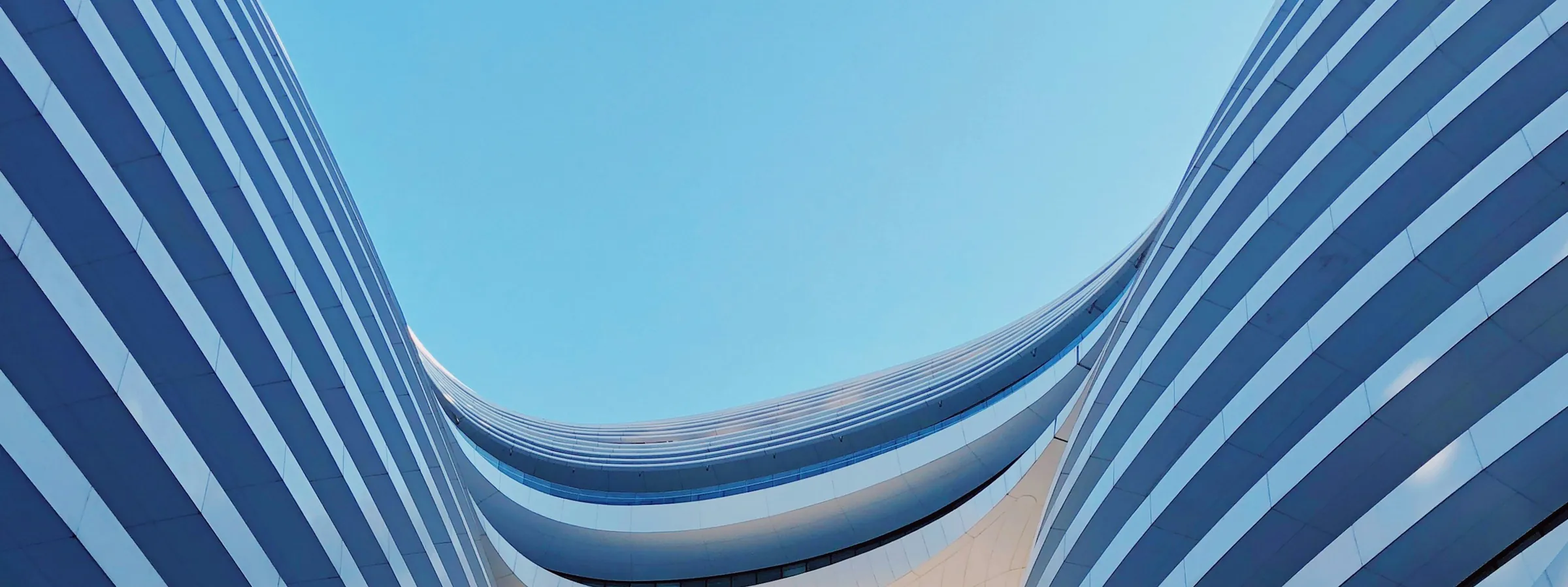 A curved tower facade sweeping against open sky