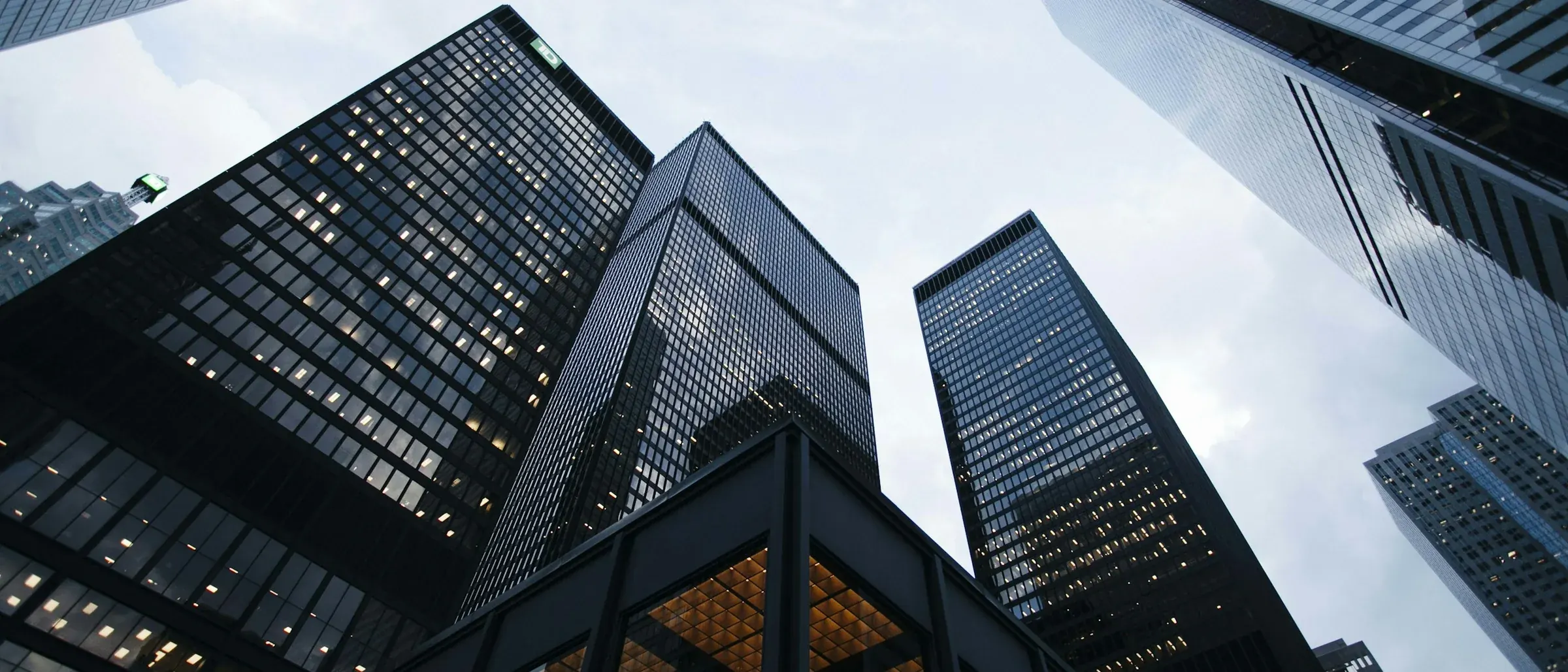 Glass office towers seen looking upward against a bright sky