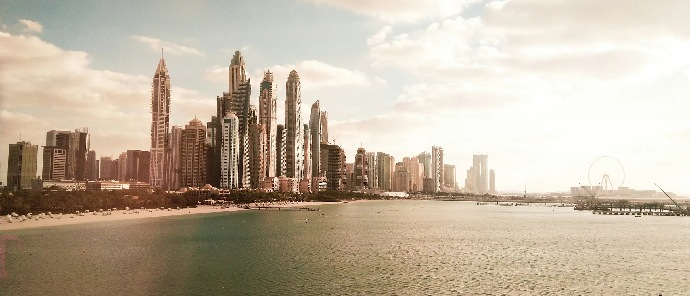 The Dubai skyline across the water under a clear sky
